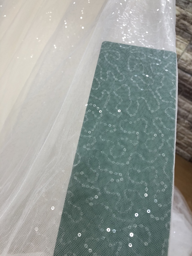 チュール下の繊細に展開されるスパンコールが光の当たり方によって絶妙なバランスで輝きます。